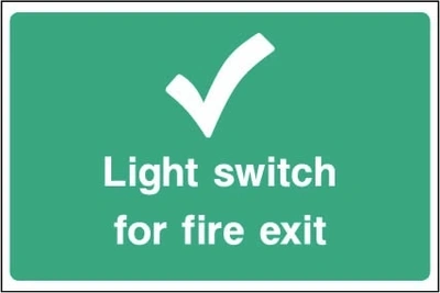 Light switch for fire exit sign showing tick symbol and switch identification. Artwork EMER0097.